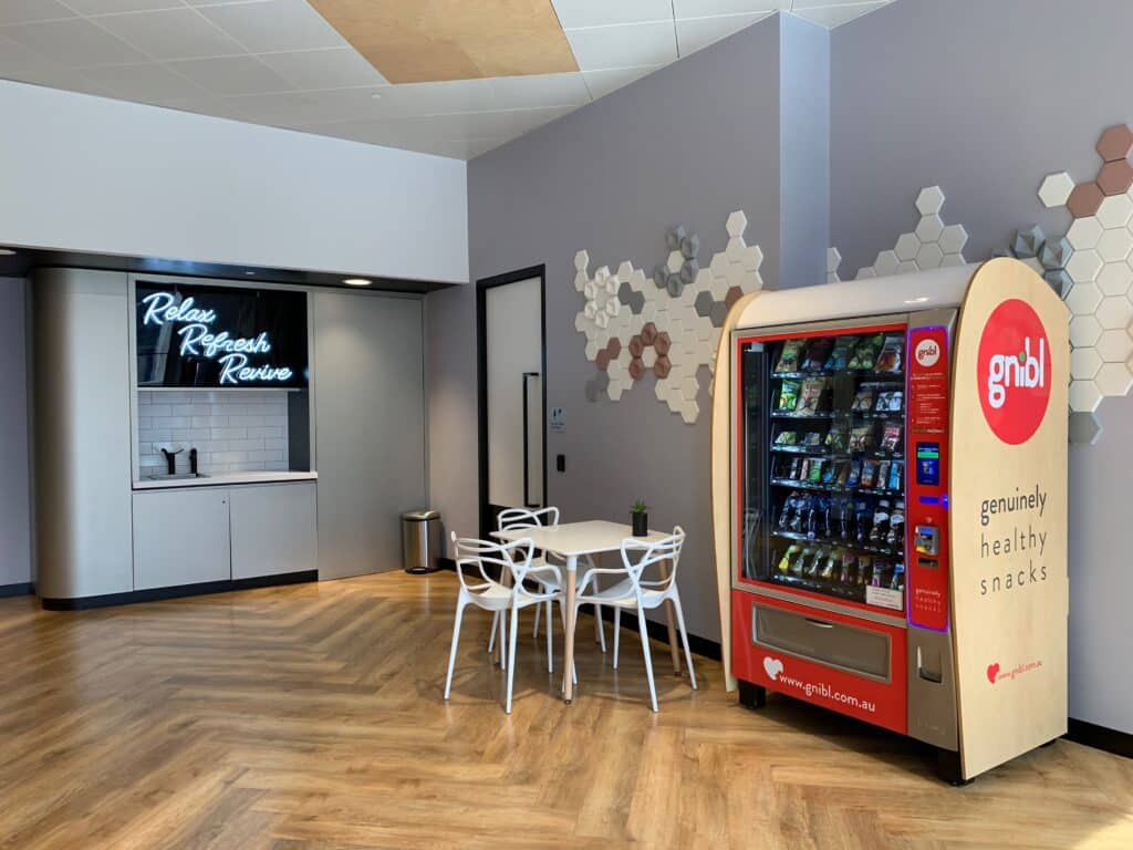 Gnibl Vending machine placed in a workplace break area with a small white table